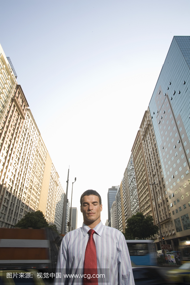 商人在城市街道闭上眼睛(模糊运动背景)