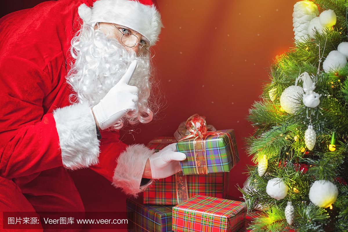 圣诞老人放礼物盒或礼物在圣诞树下