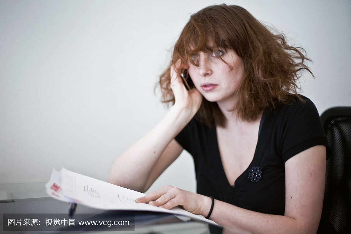 坐在桌子上的凌乱的头发的少妇