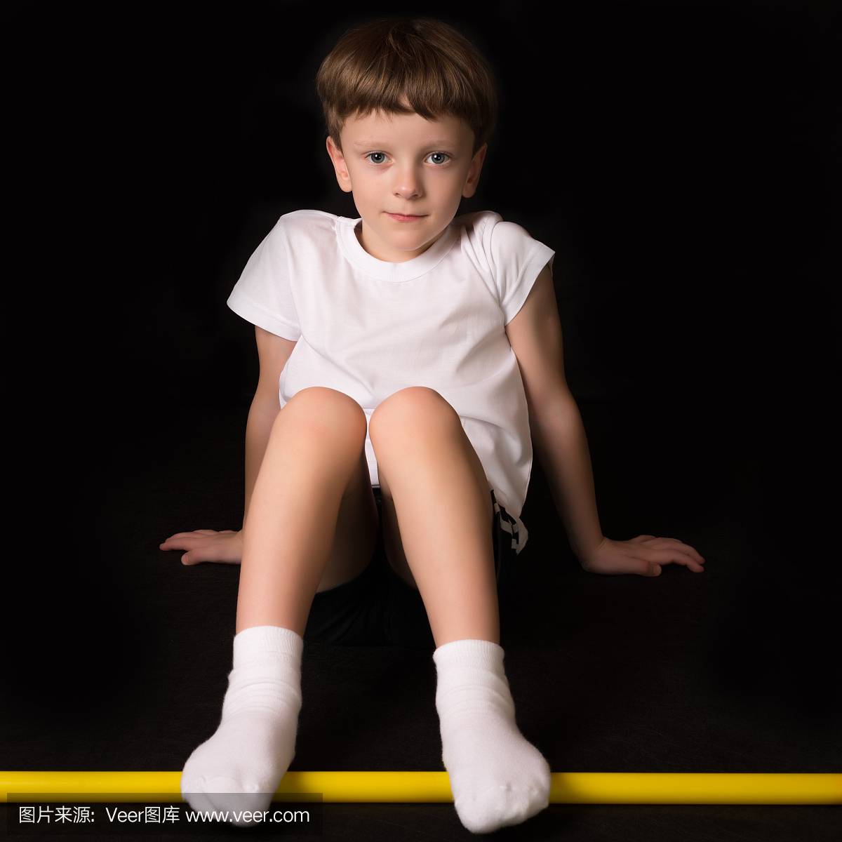 男孩运动员在健身房里用健身棒锻炼身体