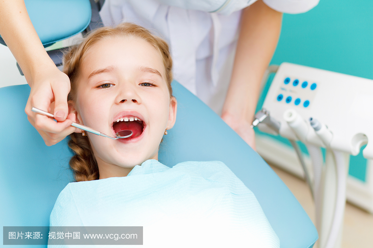 Little girl sitting in the dentists office