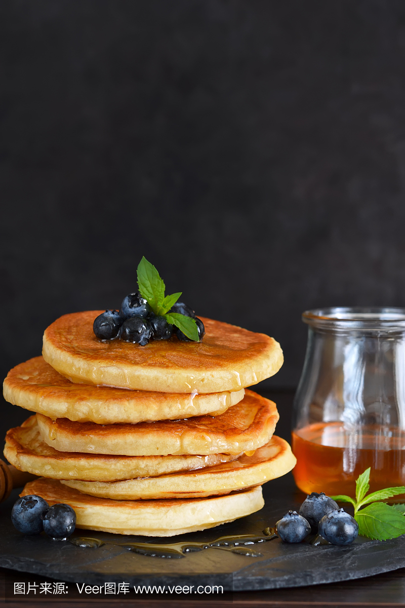 蜂蜜和蓝莓自制燕麦煎饼在石板上吃早饭。早上