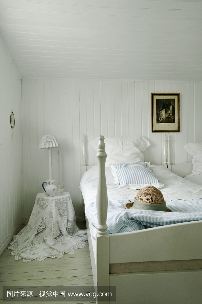 带白色复古床单和蕾丝窗帘的卧室。