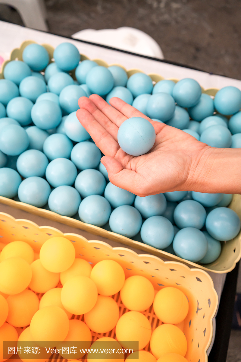 Hand holding blue ping-pong balls.