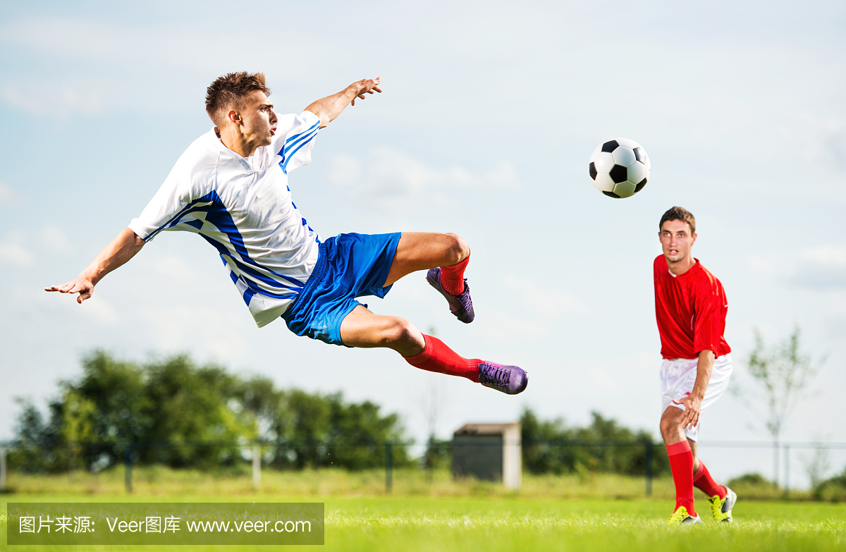 足球运动员在半空中踢球。