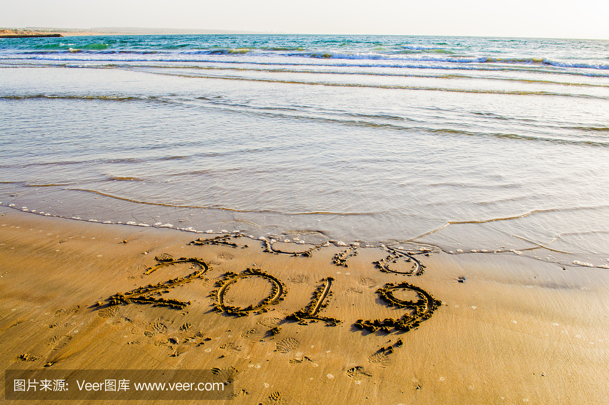 新年快乐2019海滩上的文字。即将到来的新年