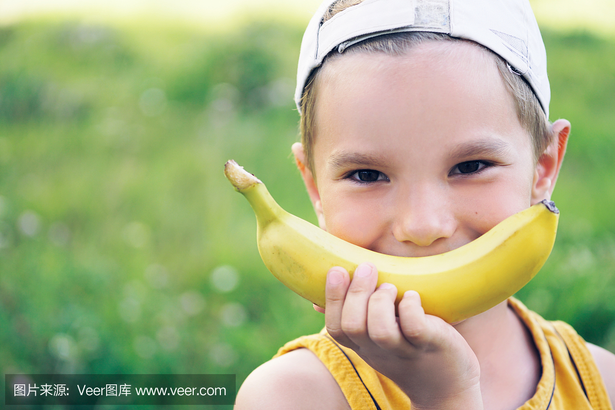 美丽的年轻白人男孩戴着帽子的脸上用自然背景