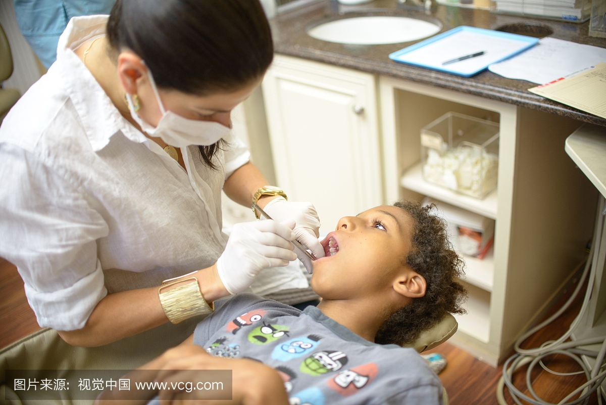 女牙齿矫正器检查男孩在牙科手术