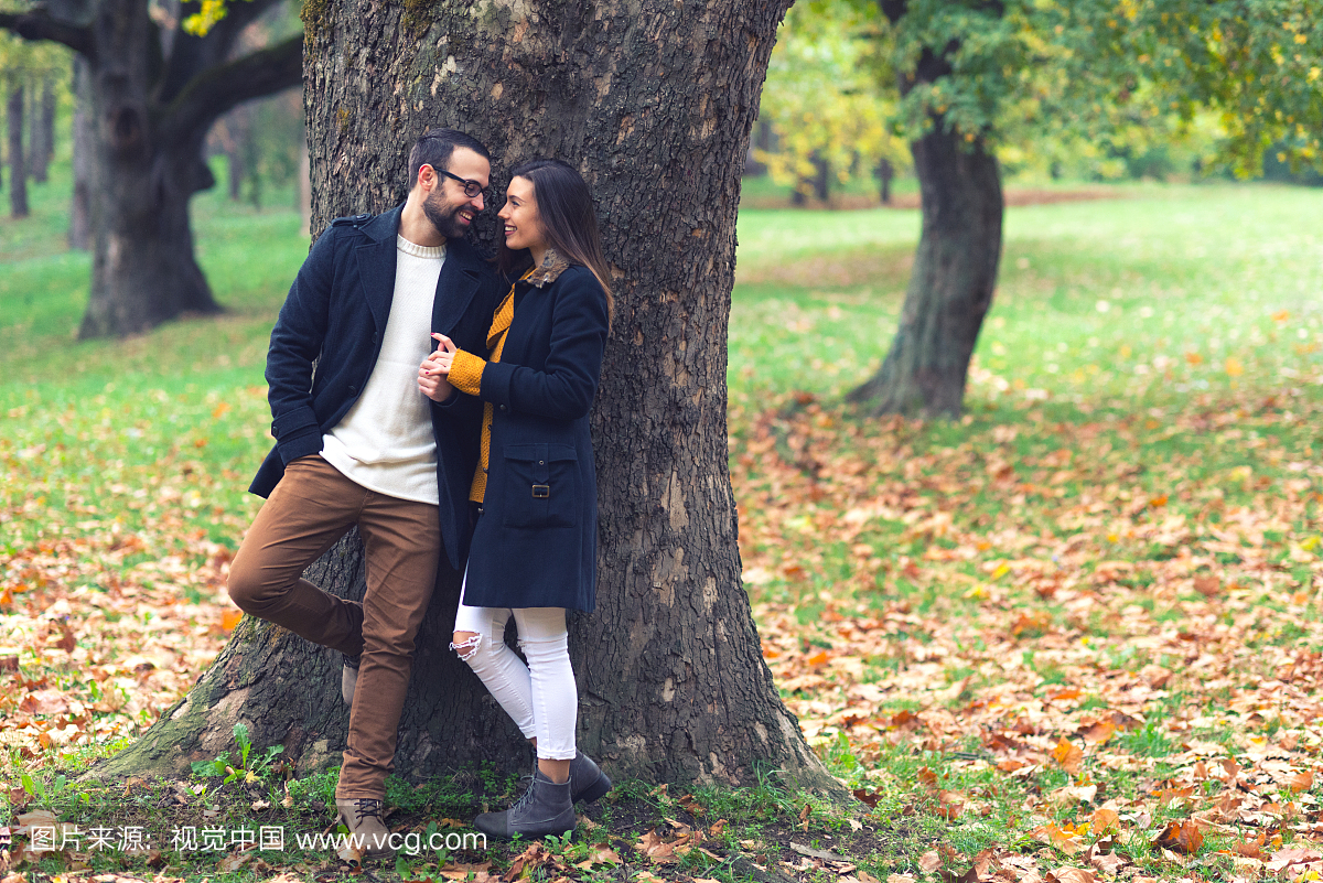 恩爱的夫妻在秋天的公园交换温柔