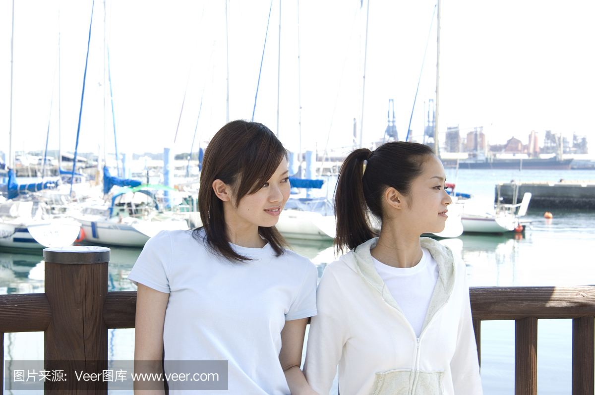 两个年轻的日本妇女放松在港口