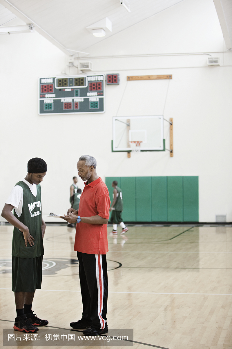 非洲教练和篮球运动员在健身房进行评估