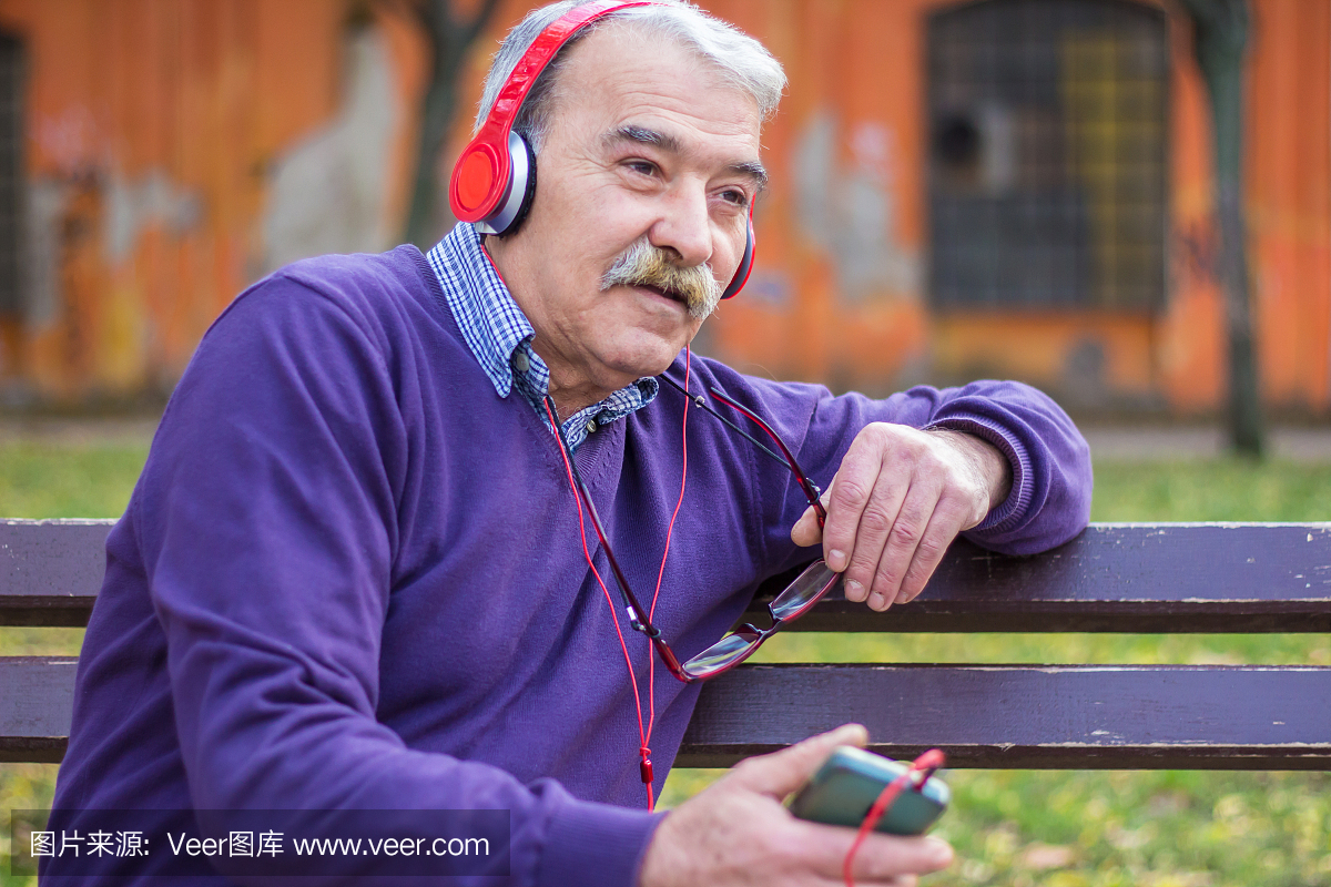 带耳机听音乐的老男人。