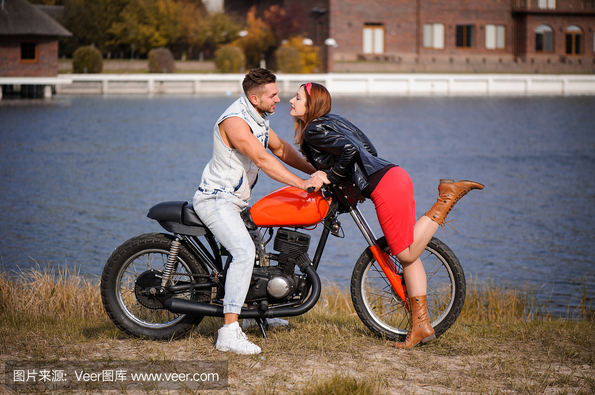 时尚和新潮夫妇在爱情上躺着的摩托车调情特写