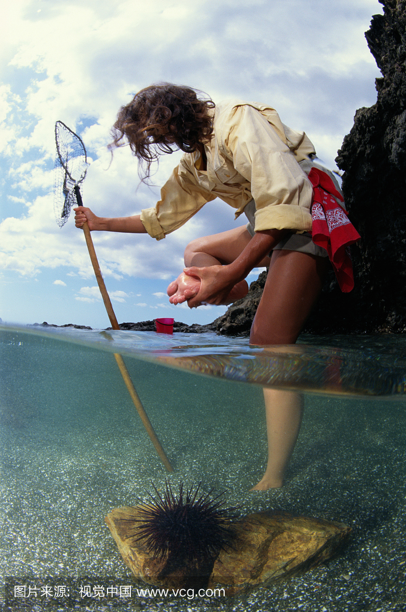 靠在钓鱼网上的女人抱着脚,部分水下视野