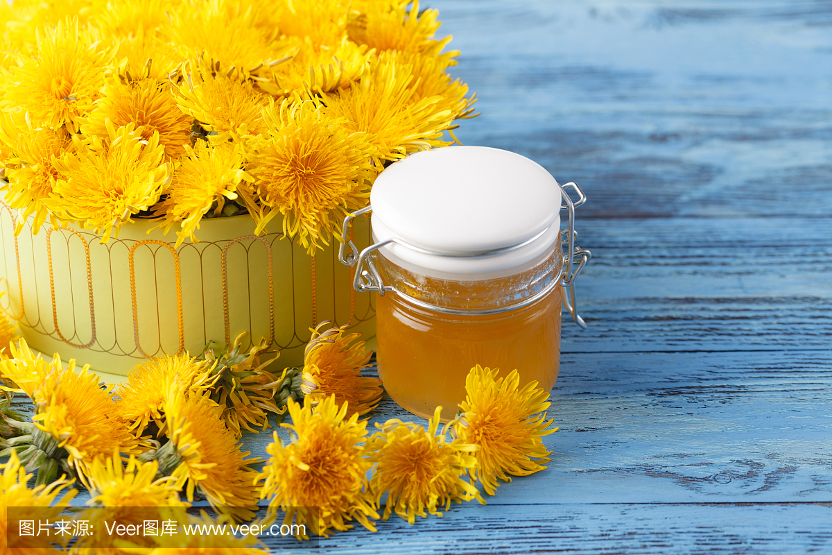 蒲公英蜂蜜在一个罐子和鲜花