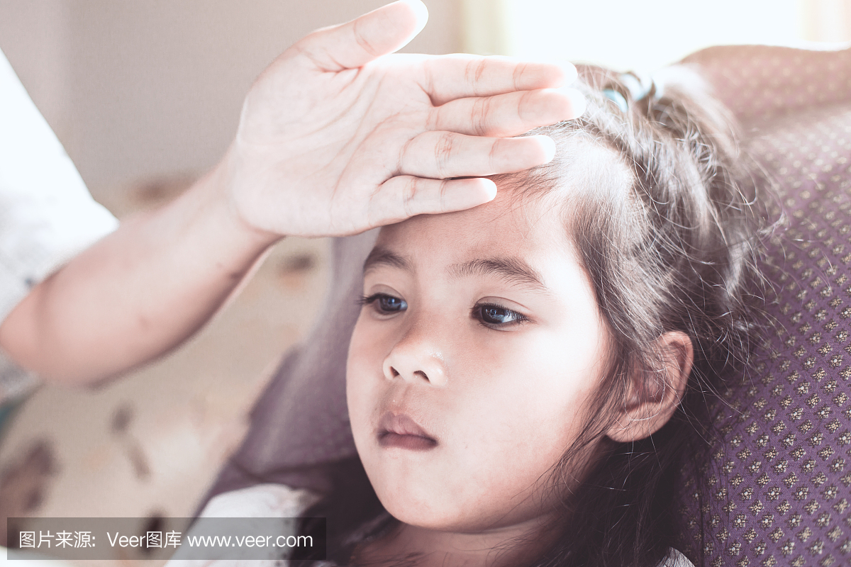 可爱的亚洲孩子女孩病和母亲的手触摸她的额头