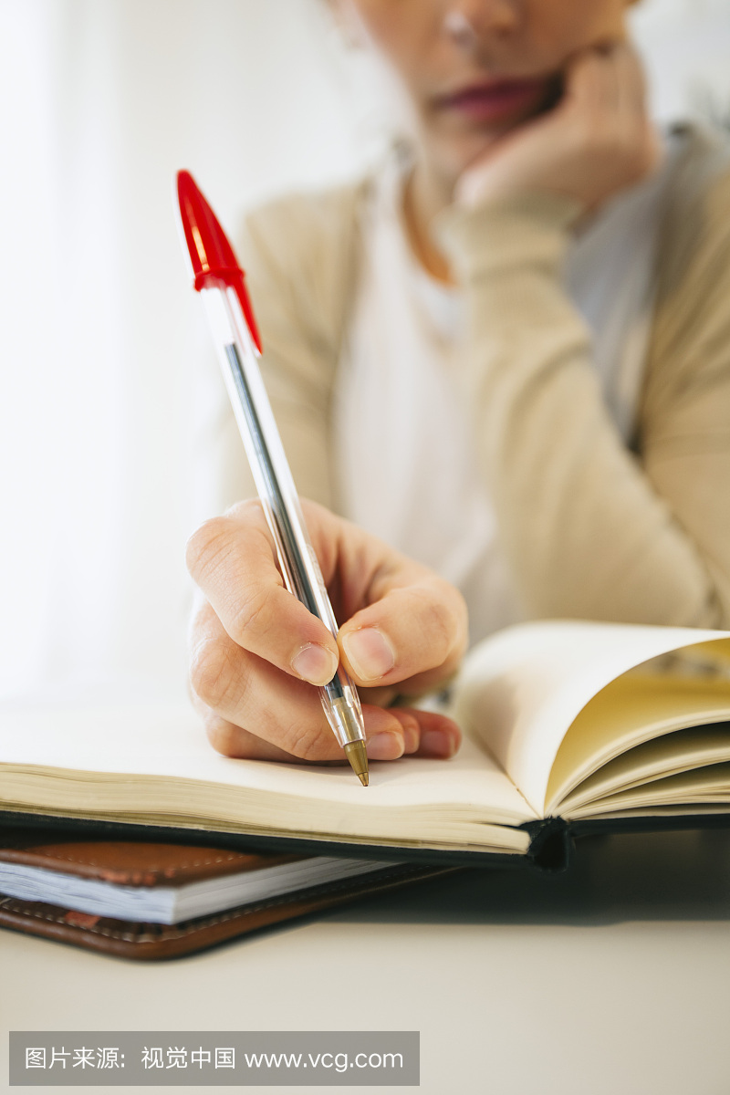 女人用圆珠笔写下东西,细节