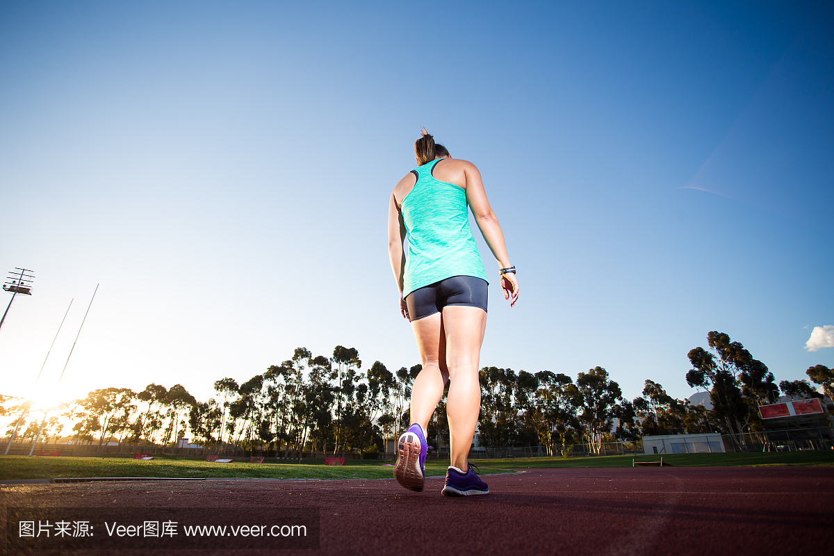 女子短跑运动员\/运动员在柏油碎石田径跑道上