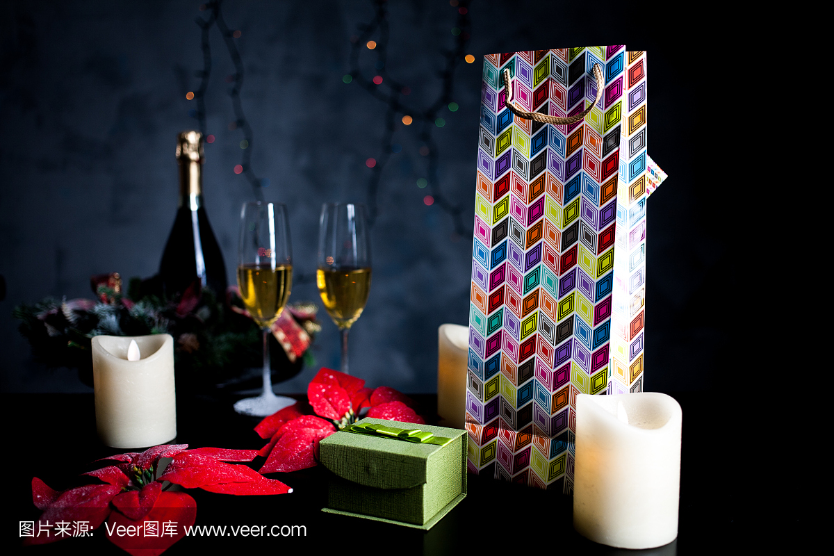 在一张黑色的桌子上的圣诞礼物背景的眼镜和瓶