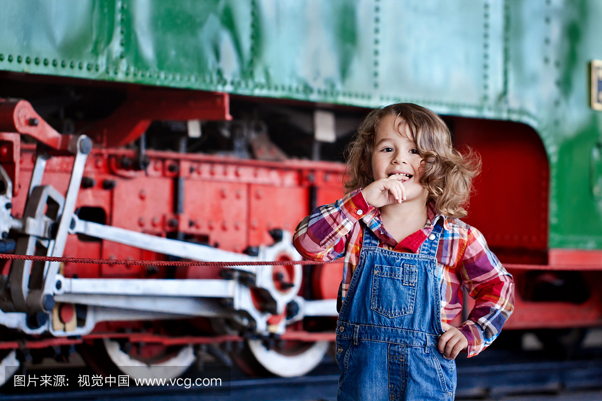 长长的头发在火车前面的男孩