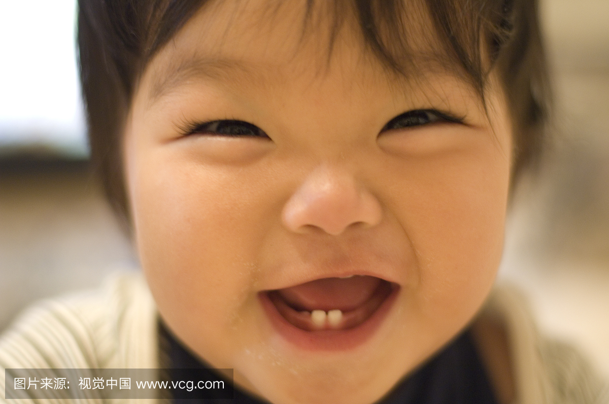 An one-year-old girl laughing in the living room 