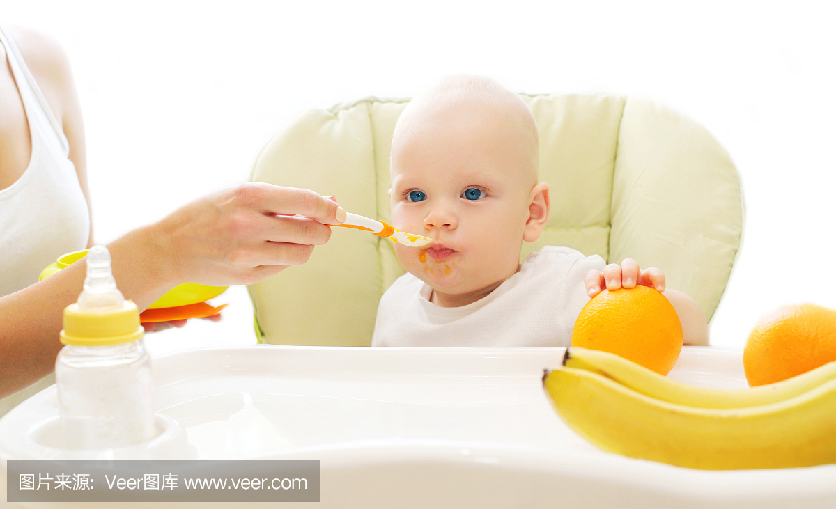 妈妈把婴儿勺子放在家里的桌子上