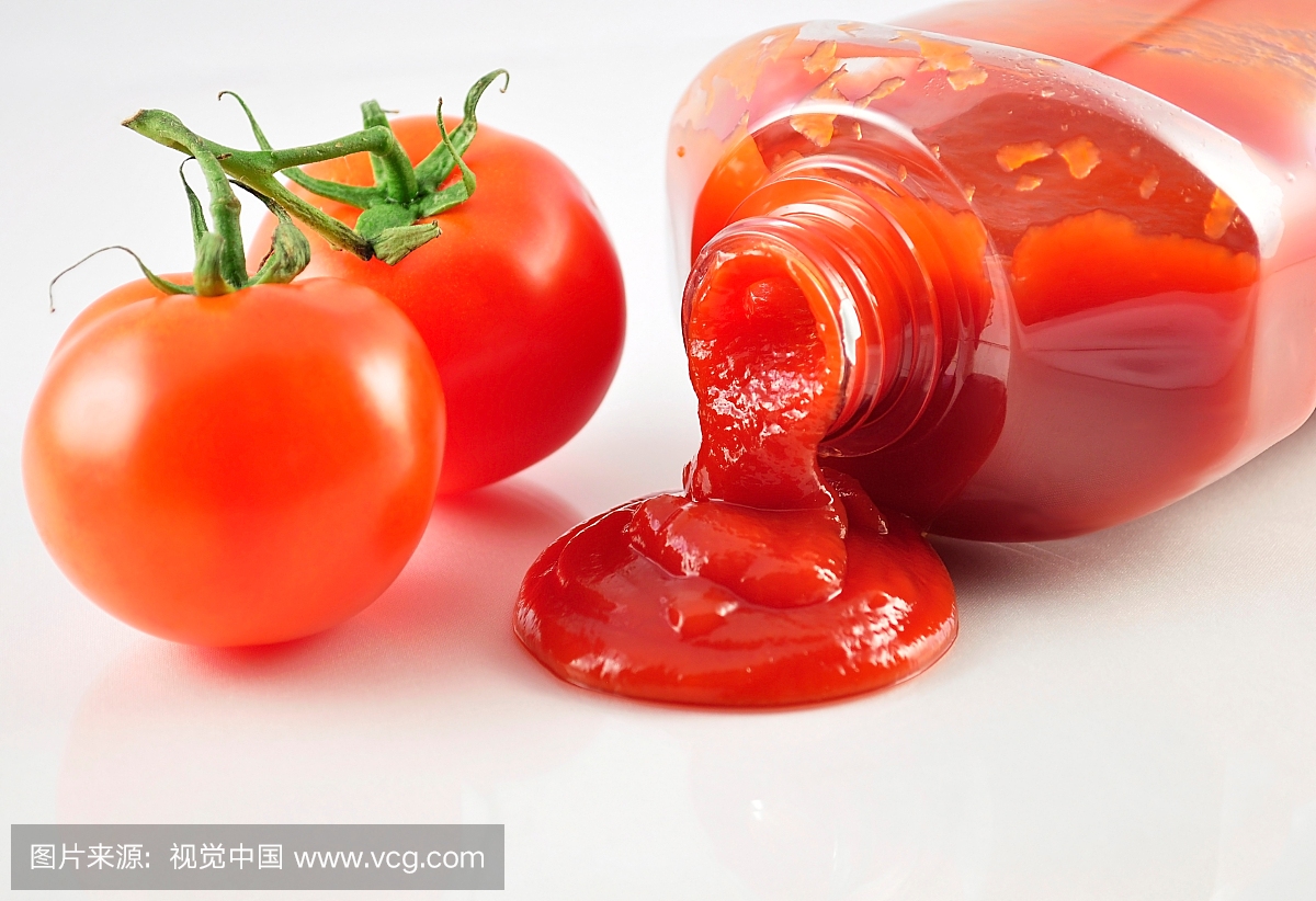 tomato ketchup and fresh tomatoes , close up