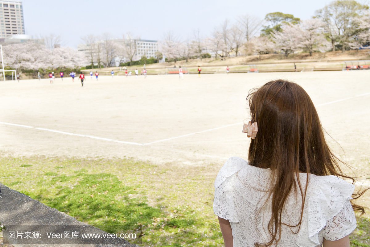 长长的棕色头发的女人外面的足球游戏