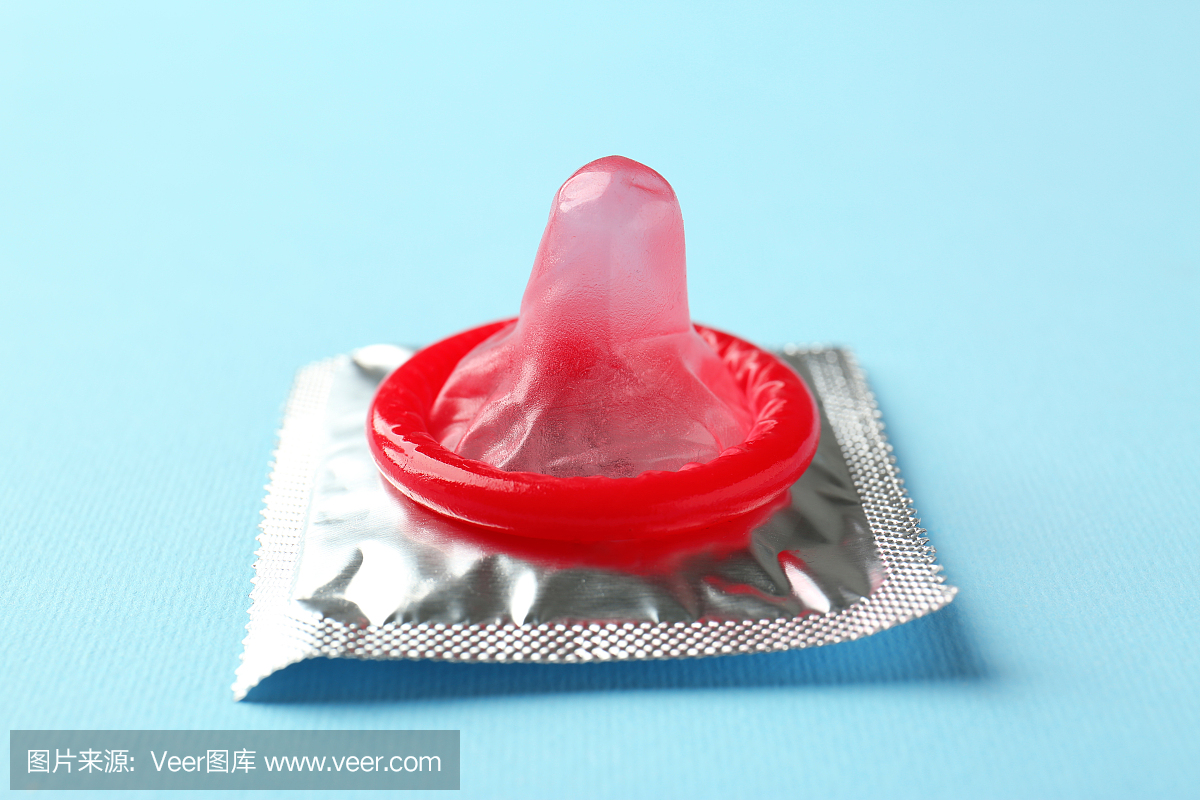 打开并包装在颜色背景上的避孕套。安全的性爱