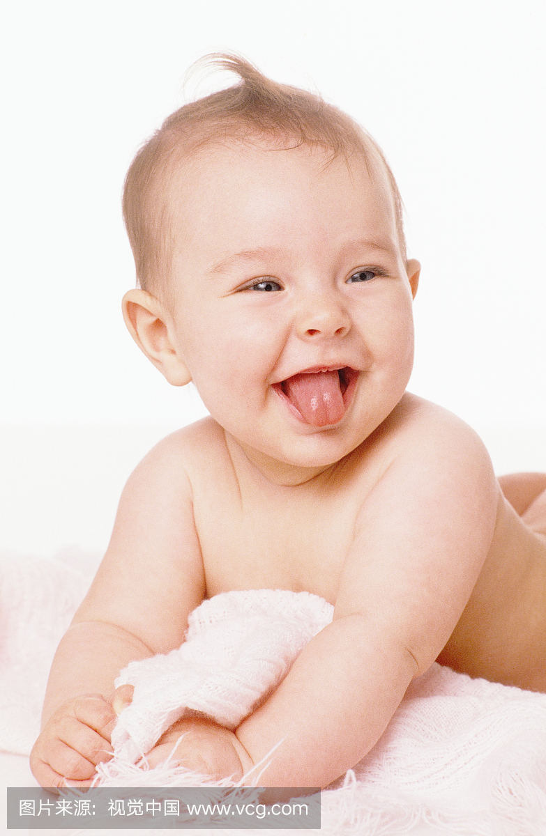 宝贝女孩(2-5个月)躺在毯子上,伸出舌头