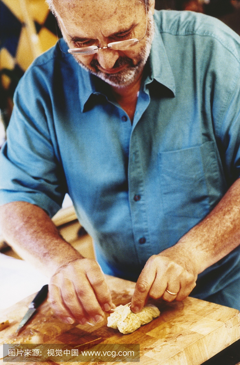 Man tying stuffed savoy cabbage leaf with string