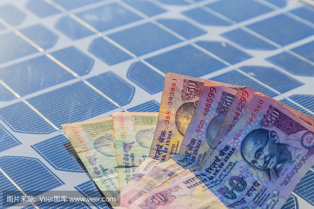 印度货币纸币在太阳能电池板在天亮。