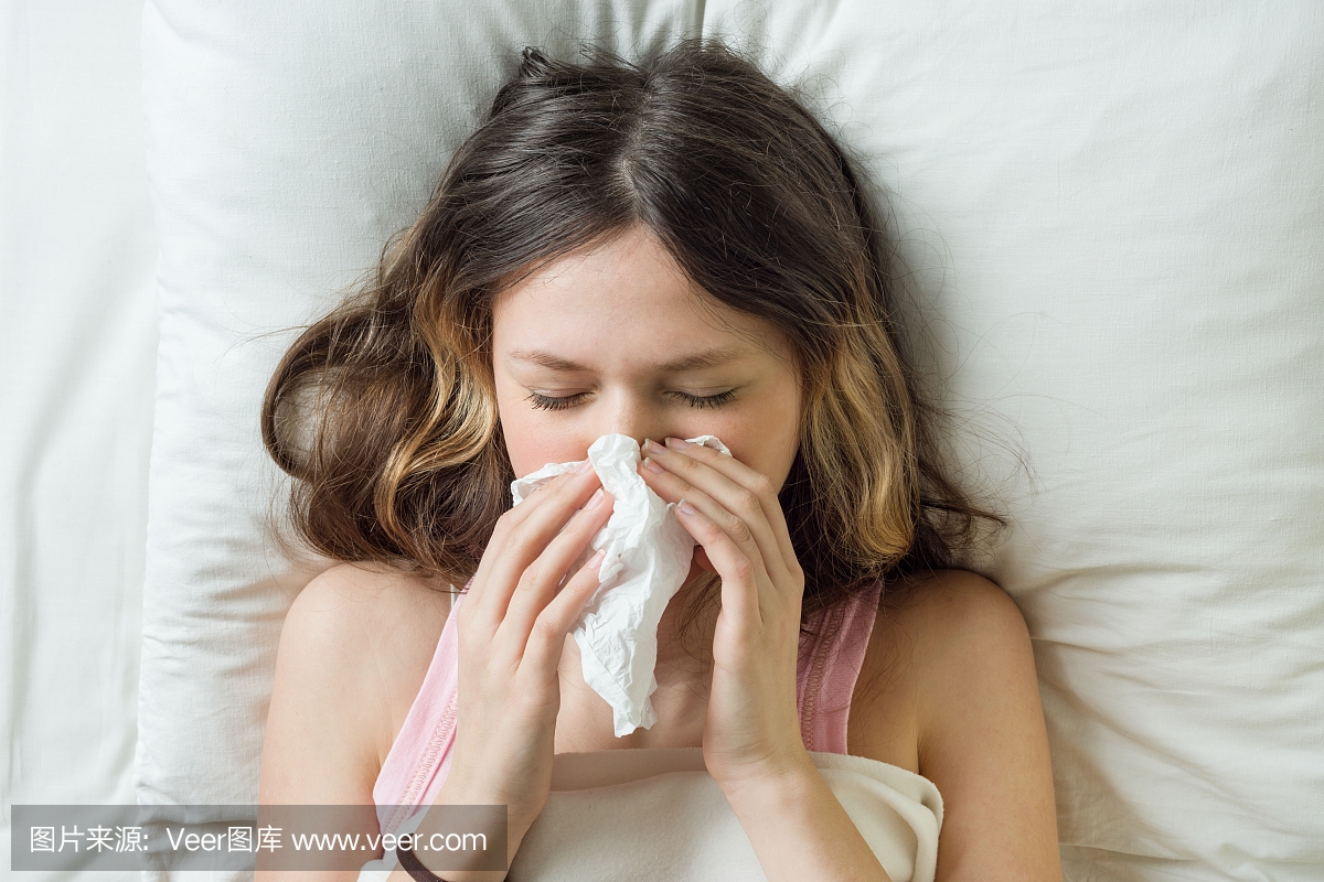 流感季节流感,流鼻涕。生病的女孩在床上用手