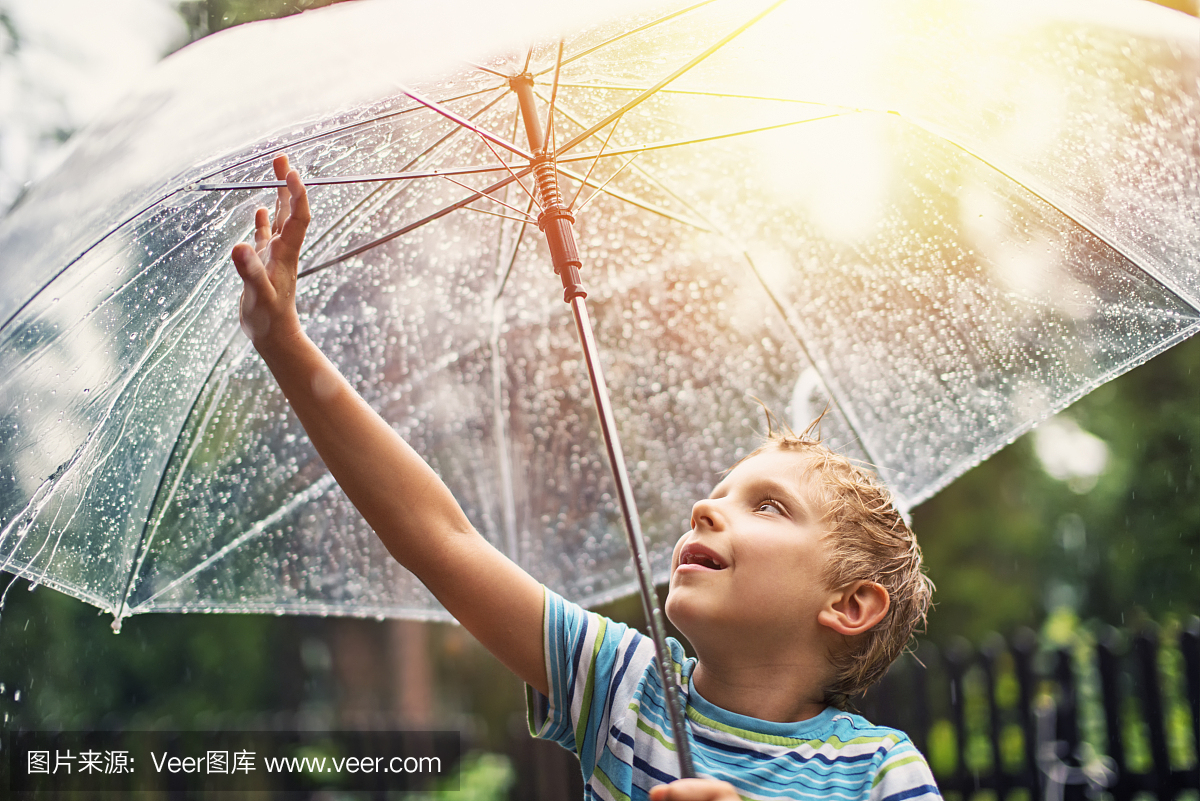 透明伞的小男孩享受雨。