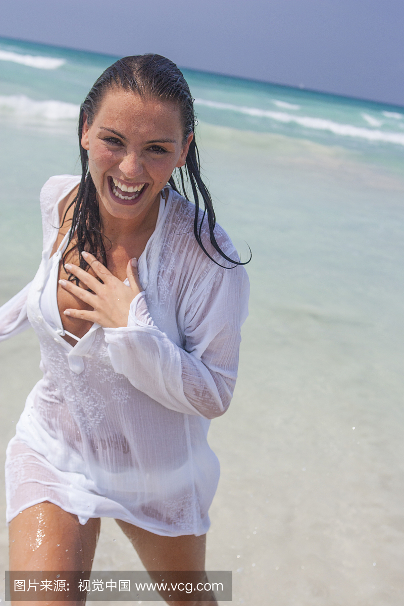 快乐的年轻女子跑出海面与湿头发,马略卡岛,西