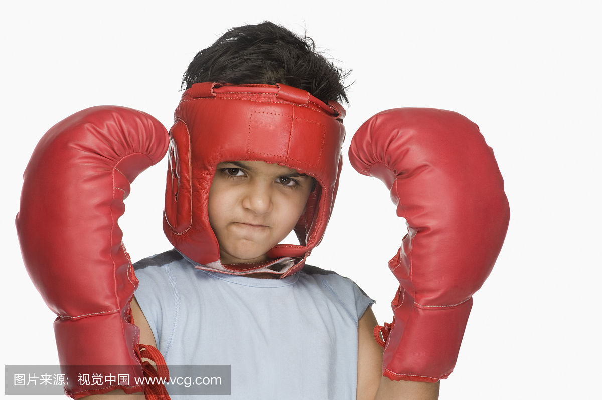 一个男孩的肖像穿拳击手套和头部保护