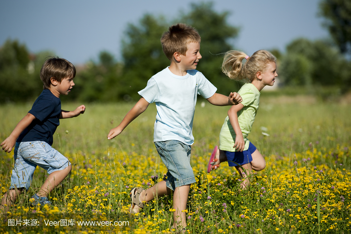 三个孩子跑过草地