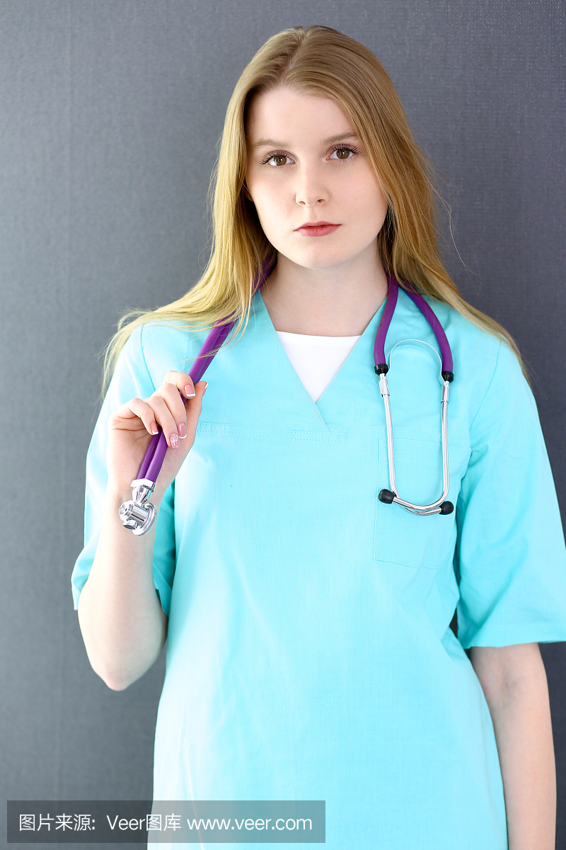 女医生或护士直直站在医院。绿色的统一颜色。